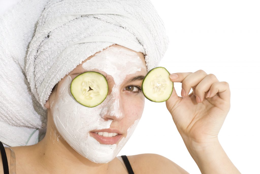 Anti-Aging Beauty Secrets with Girl wearing face moisture mask with cucumbers over her eyes.